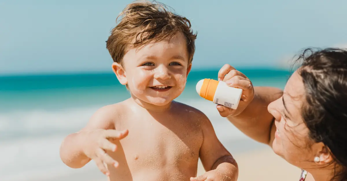 Women experiencing prenatal sunburn applying sunscreen to her son