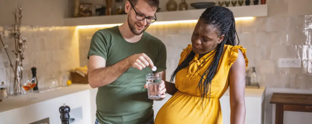 Pregnant women taking prenatal vitamins with husband